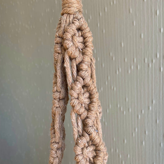 Close up of macrame knots on a beige macrame plant hanger