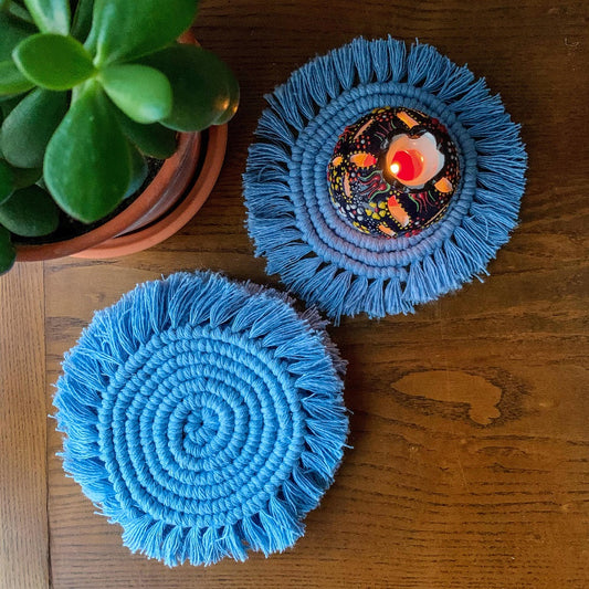 2 macrame round tea coasters with a small candle holder on it.