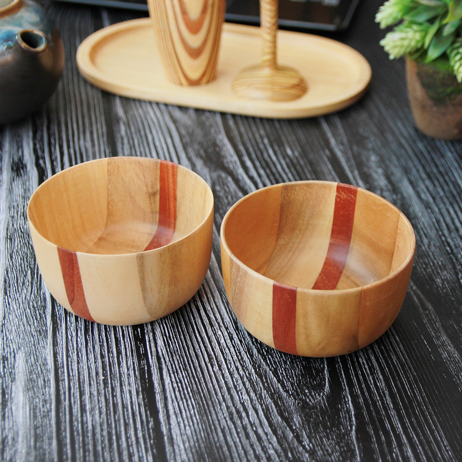 Two wooden handmade bowls in birchwood with a black sirish wood accent.