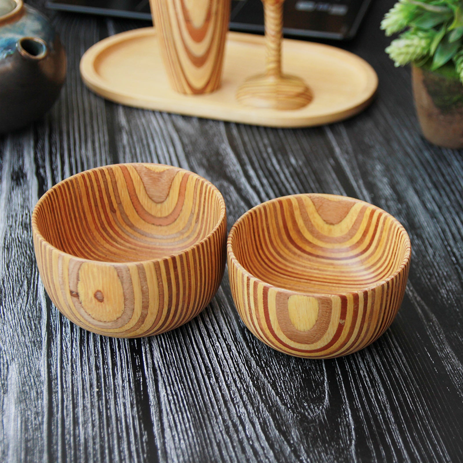 Two wooden handmade bowls in a patterned plywood style.