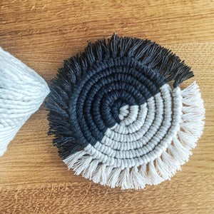 A round macrame coasters hanmade with black and white cotton yarn.