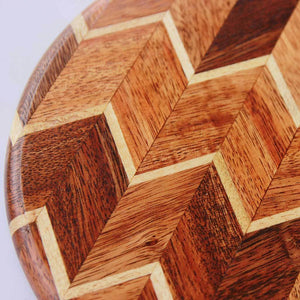 A chevron pattern cheese board or cutting board made from walnut wood and birch wood.