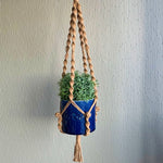 Load image into Gallery viewer, Brown macrame plant hanger with a succulent houseplant in a blue planter hanging from the ceiling
