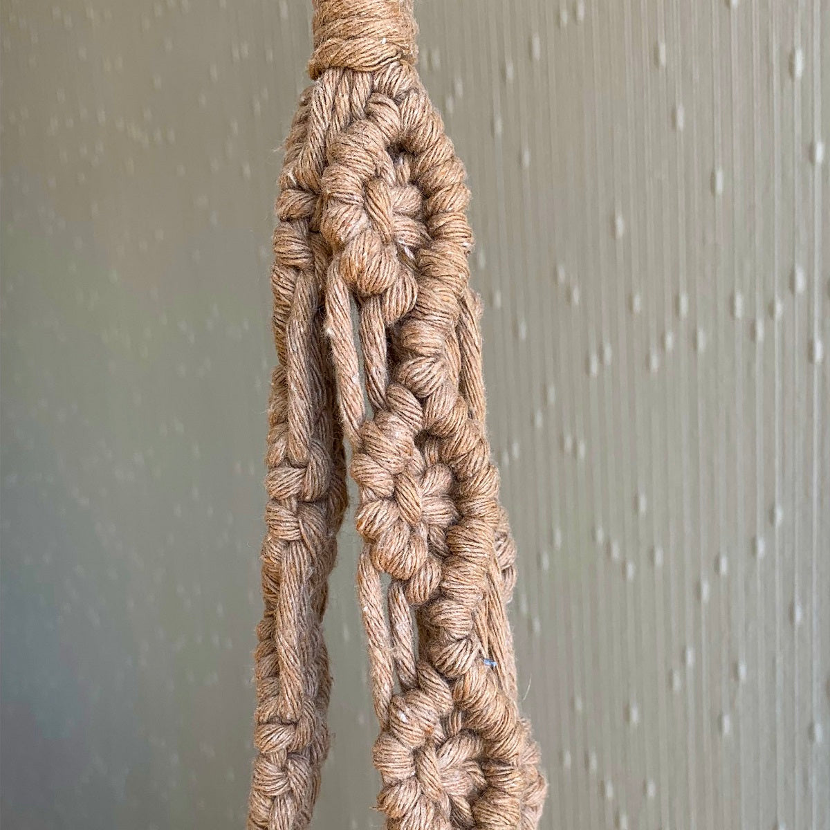 Close up of macrame knots on a beige macrame plant hanger