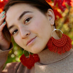 Load image into Gallery viewer, A woman wearing a fringed boho earrings that is handmade with cotton yarn in burnt orange.
