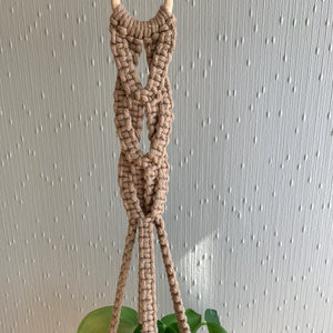 Close up of macrame knots on a brown macrame plant hanger.