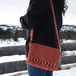 Load image into Gallery viewer, A woman carrying a brick coloured woven shoulder bag with a detachable strap
