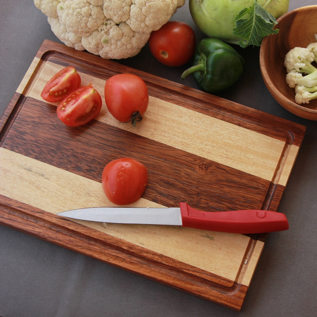 Pieces of tomatoes on a walnut wood and birch wood striped chopping board
