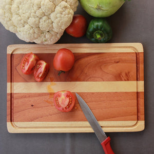 Chopped tomatoes on a mahogany wood and birch wood striped cutting board