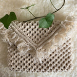 Load image into Gallery viewer, A white macrame envelope clutch bag on a white table with an ivy plant
