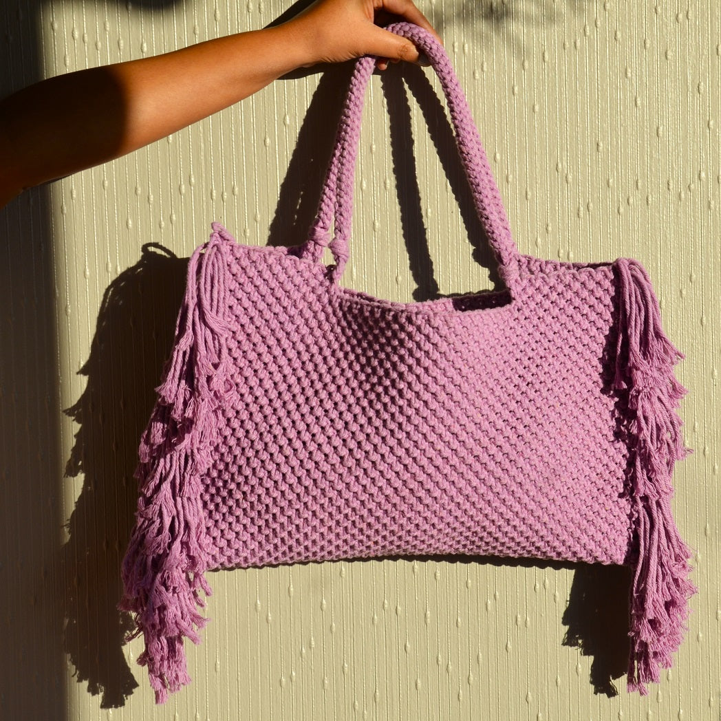 A lavender coloured handcrafted tote bag with fringe detailing